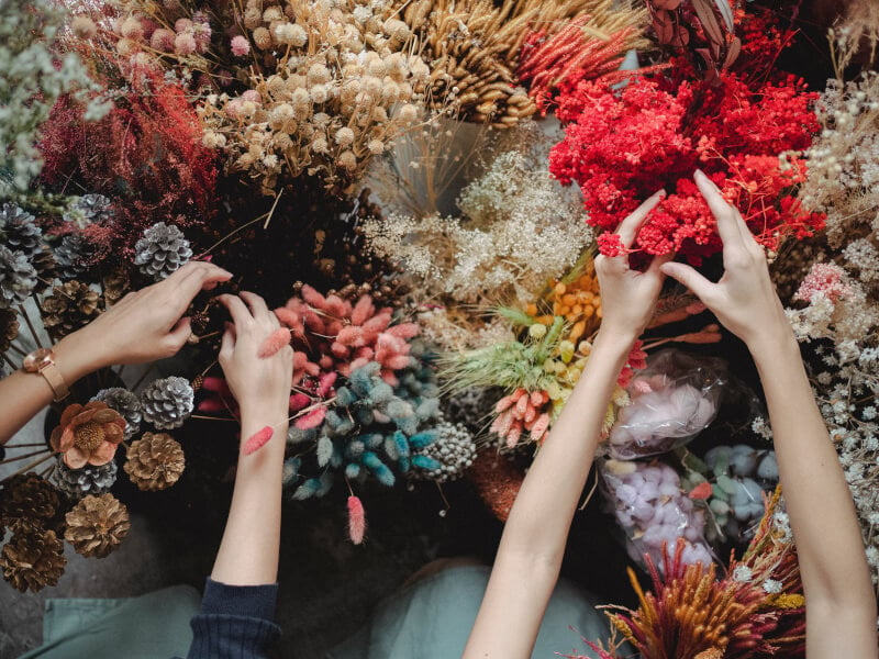Women arranging dried flowers at a floristry class they were gifted for Mother's Day